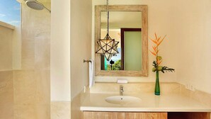 A bathroom with a large mirror, a sink, and a shower. - 353 Degrees North (Penida Island)
