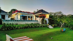 A modern house with a stone facade, a covered patio, and a well-maintained lawn. - 353 Degrees North (Penida Island)