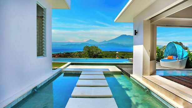 A modern pool area with a clear view of mountains and a body of water in the background. - 353 Degrees North (Penida Island)