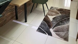 Un intérieur moderne comprenant un escalier, un coin repas avec une table et des chaises, et une chambre à coucher avec un lit.