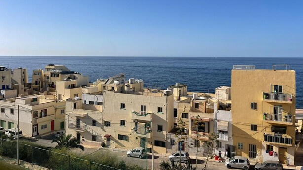 Un quartier résidentiel situé sur la côte, avec des immeubles à proximité de la mer, dotés de balcons et offrant une vue dégagée sur l’océan.