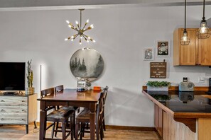 Cocina moderna con armarios de madera, un espejo redondo y un cartel que da la bienvenida a los huéspedes.