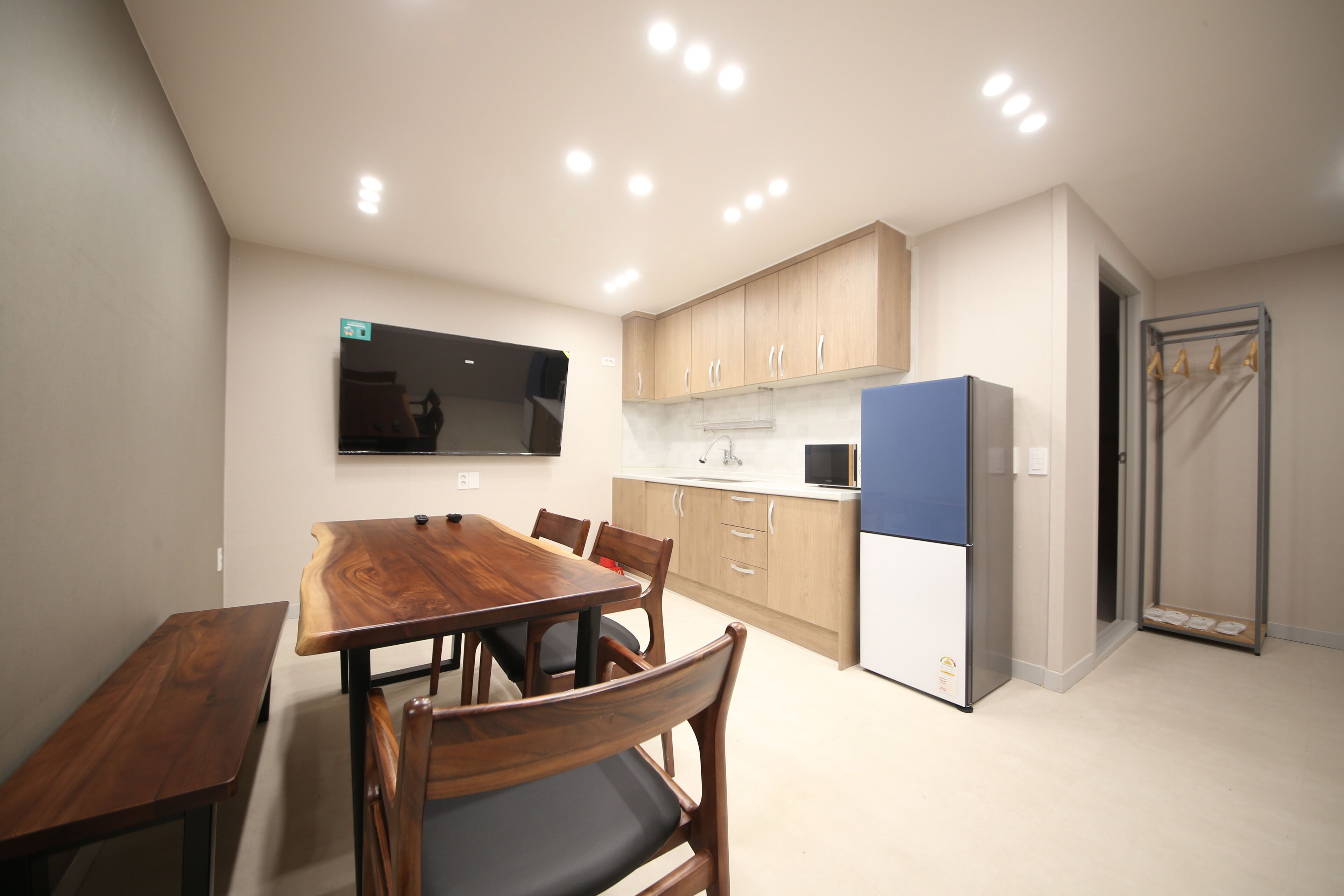 Una cocina compacta con armarios de madera, un microondas integrado y un refrigerador.