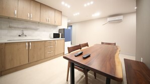 Una cocina moderna con armarios de madera, una mesa de comedor y dos controles remotos sobre la mesa.
