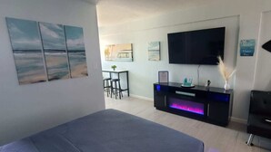 Une chambre moderne avec un lit, une télévision et des œuvres d’art accrochées aux murs.