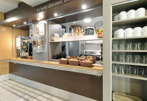 Buffet-alue, jossa on tarjolla monenlaista ruokaa, koreja ja lasiastioita.