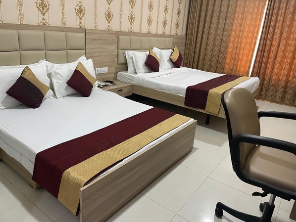 A hotel room with two beds, each with a headboard, a bedside table, and a chair. - Seth Murlidhar Mansinghka Seva Sadan (Mathura)