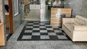 Aula, jossa on ruutukuviollinen lattia, sohva, vastaanottotiski ja seinä, jossa on maalattu vesiputousaihe.