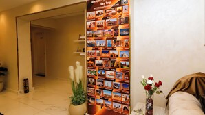 Un hall d’entrée avec une grande affiche promotionnelle de HorizonPyramids, une plante en pot, un vase de fleurs et un canapé.