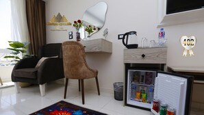 Un salon moderne comprenant un canapé, un fauteuil, une table basse, un réfrigérateur et un tapis décoratif.