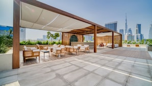 Espaço de estar ao ar livre com vista para o horizonte urbano, incluindo um arranha-céu imponente.