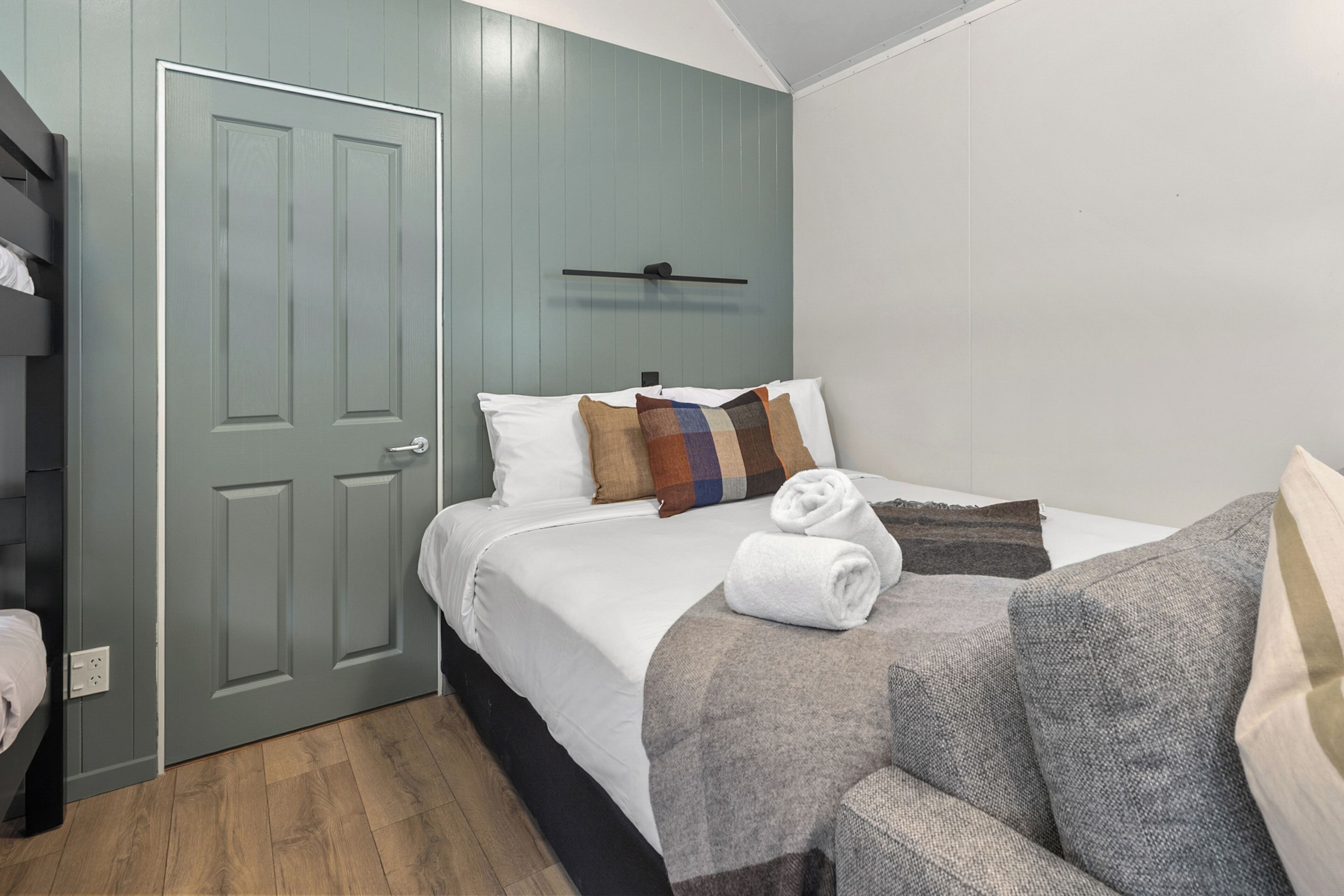 Une chambre à coucher avec un lit, une armoire, une porte et une serviette sur le lit.