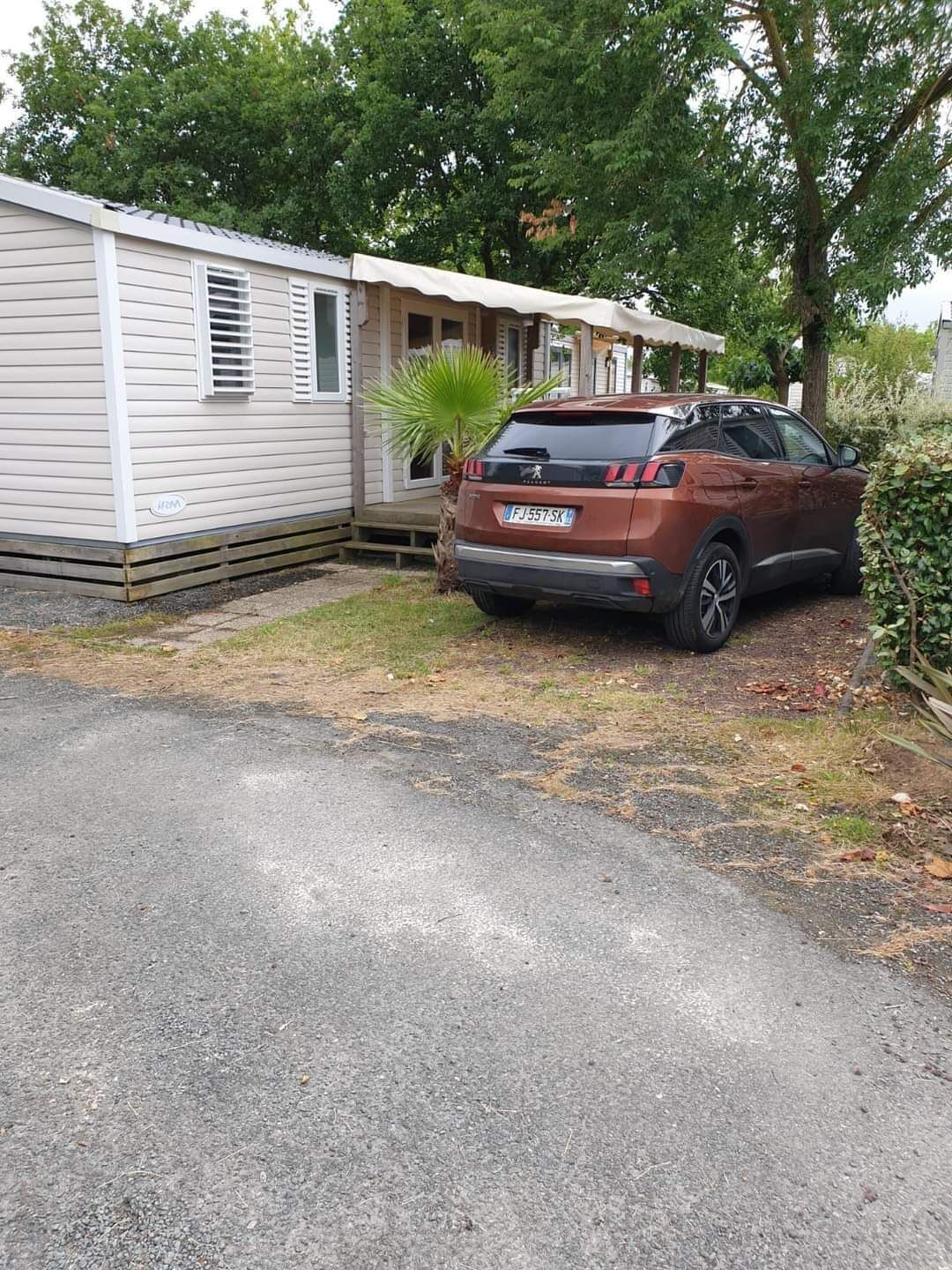 A mobile home with a car parked in front.
