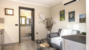 Una sala de estar moderna con un sofá gris, una mesa de centro, un reloj y decoración en la pared.