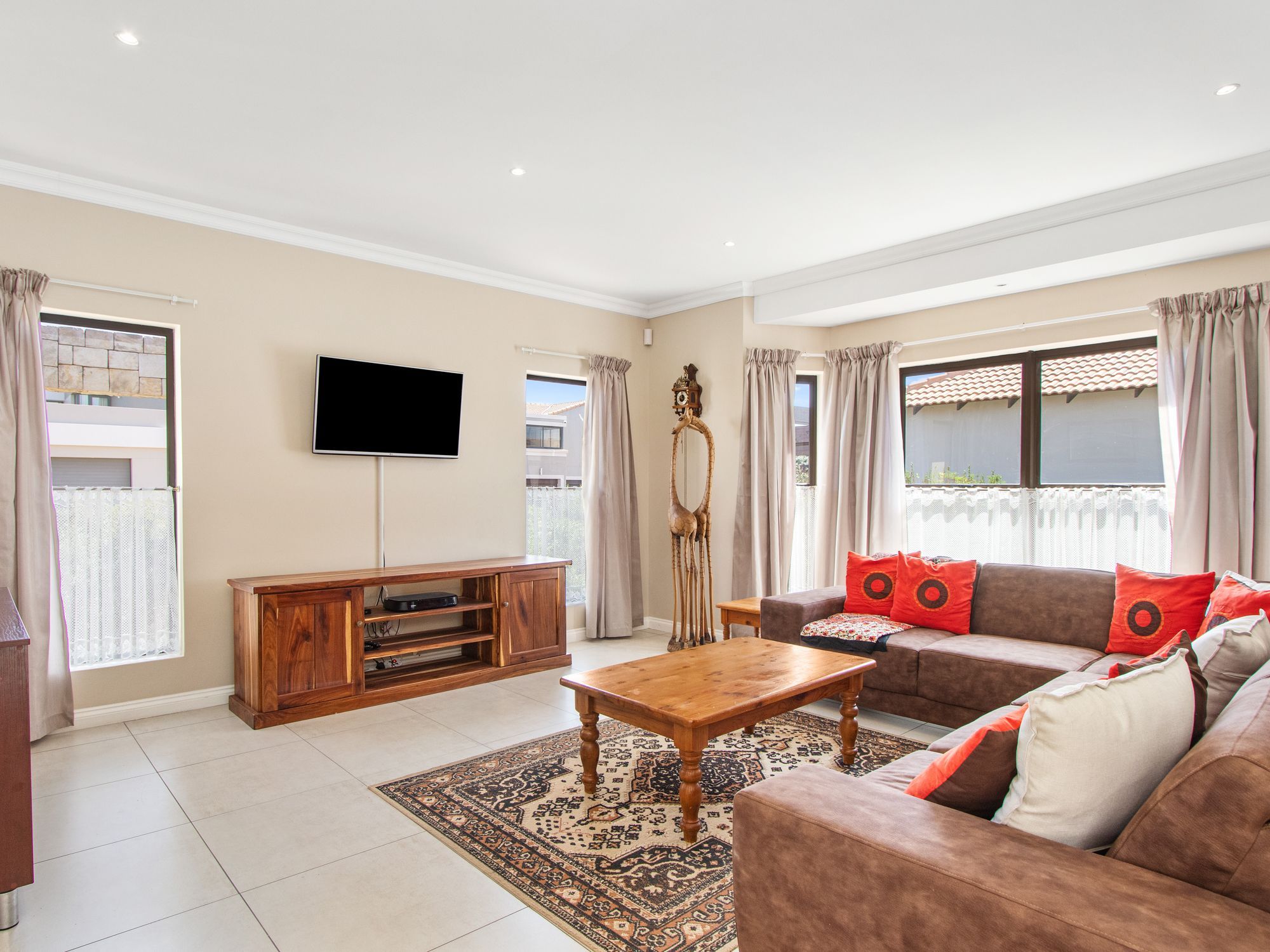 A living room with a sofa, a coffee table, a TV, and a wooden cabinet.