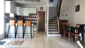 Una cocina con comedor, una escalera y vistas al exterior.