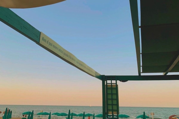 Praia particular, areia branca, espreguiçadeiras, guarda-sóis