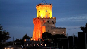 Ein Turm mit einem markanten, zentralen Turm und einem kleineren Gebäude auf derselben Basis.