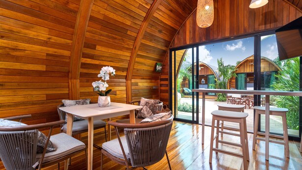 A wooden interior with a dining area, wicker chairs, and a view of the outside. - Chalet Style 2BR Pool Villa Pasak 1 (Choeng Thale)