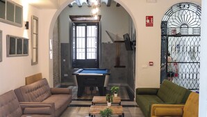 A cozy living area with a pool table, sofas, and small tables. - Hostel Ibarra by Bossh! Hotels (Seville)
