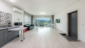 Una cucina moderna con zona pranzo, divano e televisore.