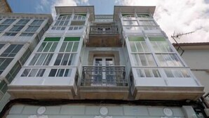 A multi-story building with a central entrance and a balcony. - "Apartamentos Bestarruza" - 2 rooms (Mugardos)