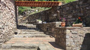 A stone staircase leading up a hill, with a wooden pergola above and potted plants at the top. - Cévennes vacations in the heart of nature in a farmhouse apartment (Cendras)