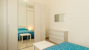 Une chambre à coucher comprenant un lit, une table de chevet, une commode et une armoire.