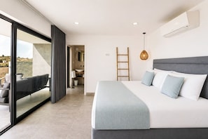 Quarto com cama grande, varanda, banheiro e vista para o exterior.