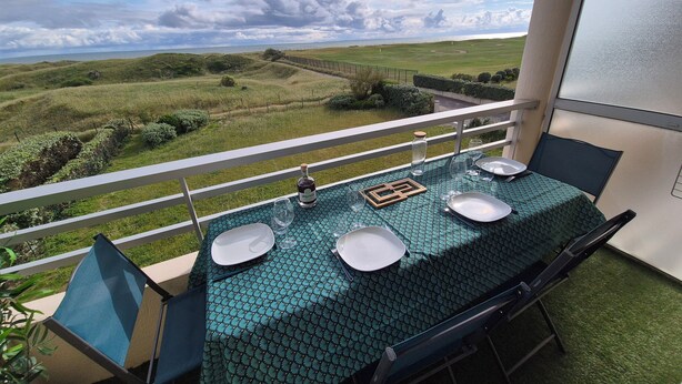 Een balkon met een eettafel, met uitzicht op een prachtig landschap.