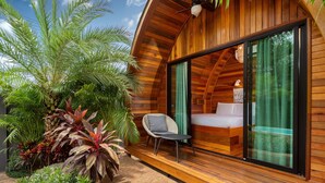 Uma cabana moderna de madeira com porta de vidro que dá para um quarto.