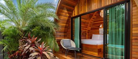 A modern wooden cabin with a glass door leading to a bedroom.