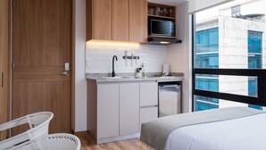 A compact kitchen with wooden cabinets, a microwave, and a dishwasher. - w* | Splendid Loft with Fantastic Deco in Bogota (Bogotá)