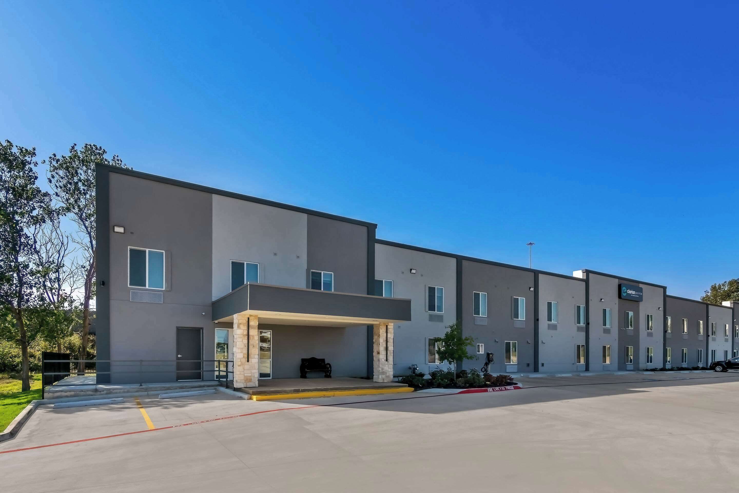 Un hôtel moderne doté d’une entrée couverte, de nombreuses chambres et d’un espace de stationnement.