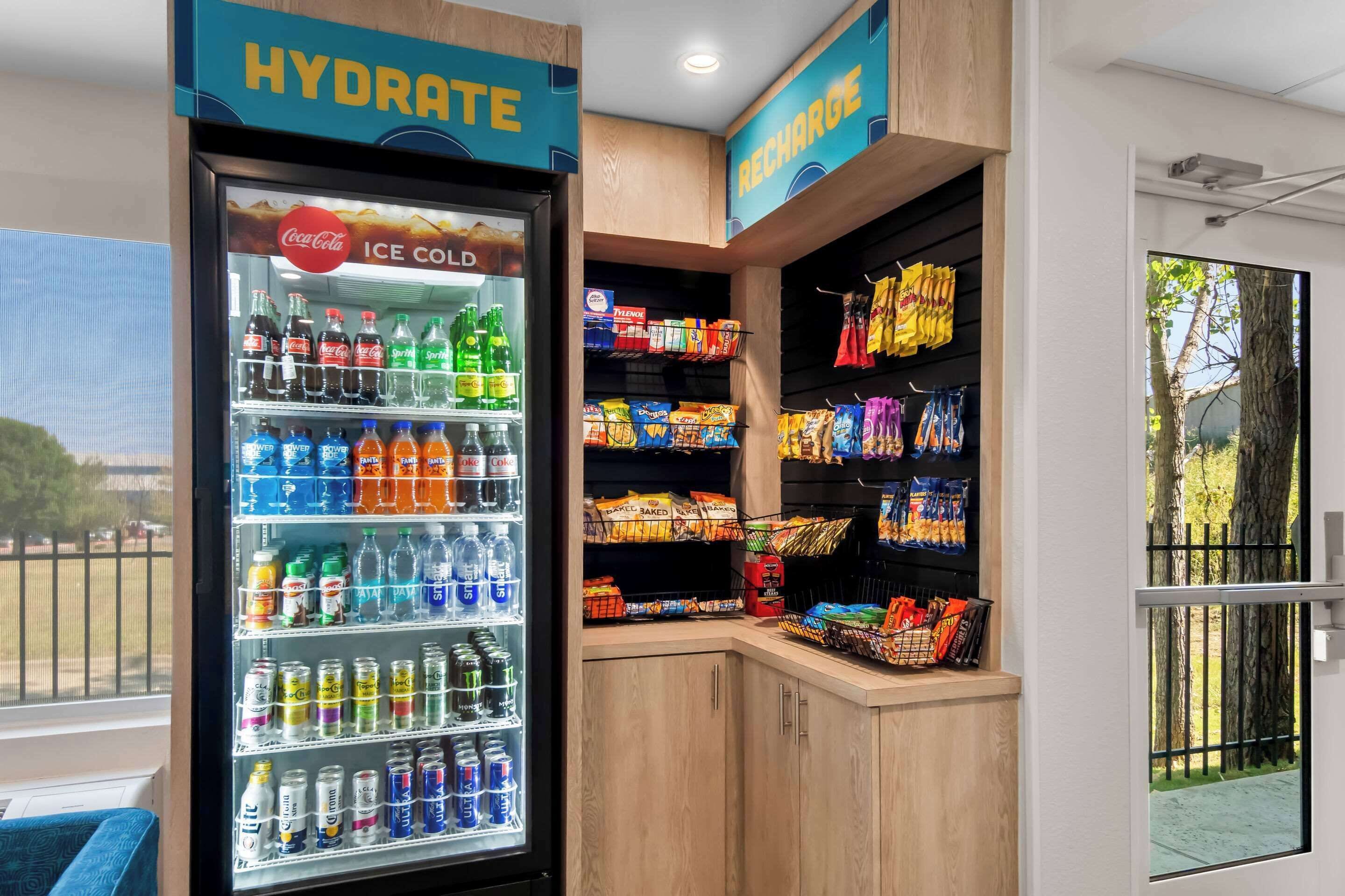 Un refrigeratore per bevande con diversi tipi di bevande e un espositore per snack.