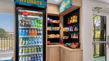 Un refrigeratore per bevande con diversi tipi di bevande e un espositore per snack.
