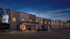 A modern hotel building with a flat facade, multiple windows, and a covered entrance area. - Clarion Pointe Fort Worth East - Arlington (Fort Worth)