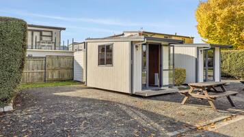 A compact, single-story mobile home with a small patio area and a picnic table.