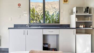 Una cocina moderna con vistas a un paisaje montañoso, microondas y refrigerador.