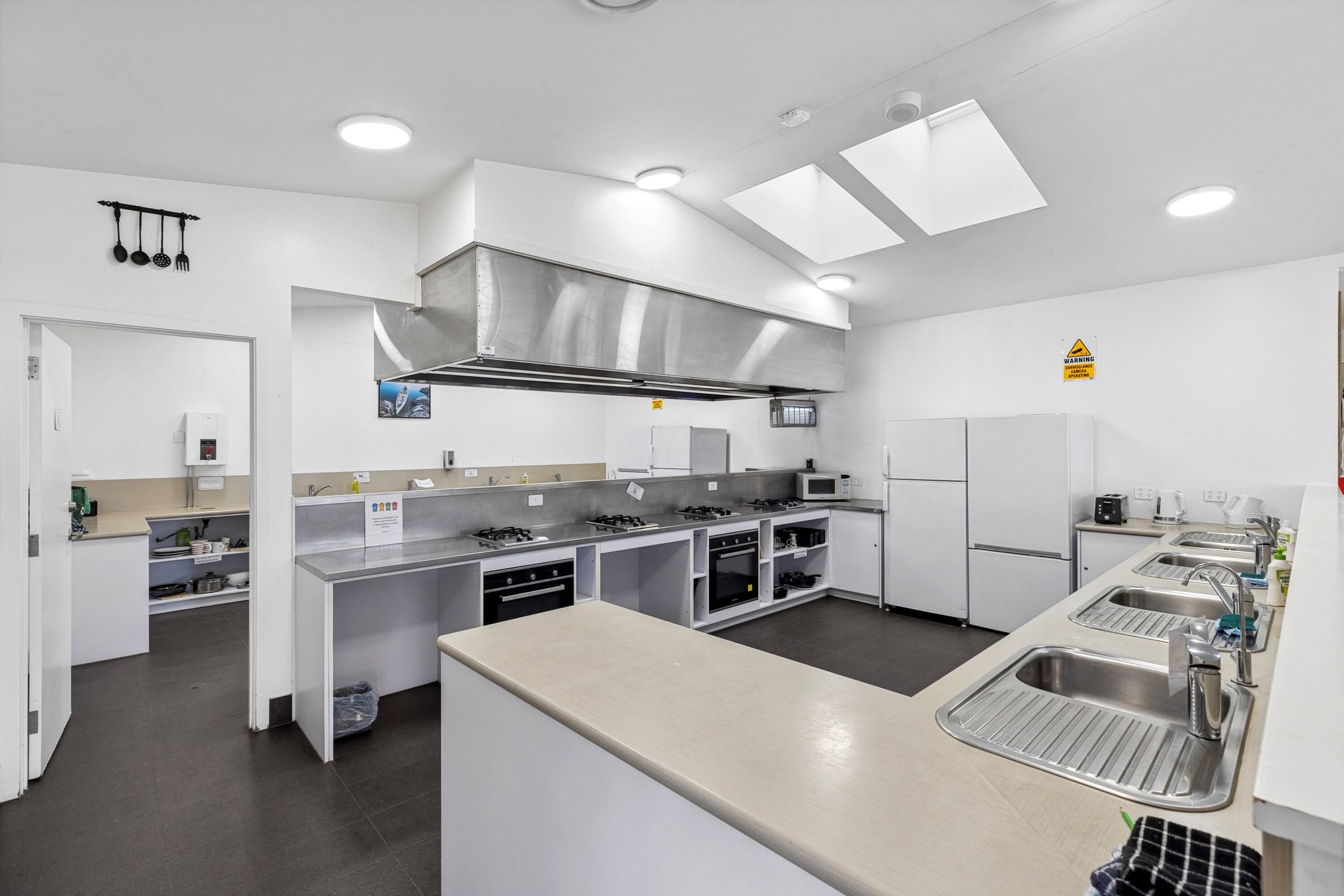 Una cucina moderna con elettrodomestici in acciaio inossidabile, un'isola centrale e illuminazione a soffitto.