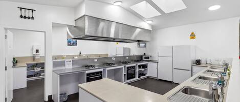 Una cucina moderna con elettrodomestici in acciaio inossidabile, un'isola centrale e illuminazione a soffitto.