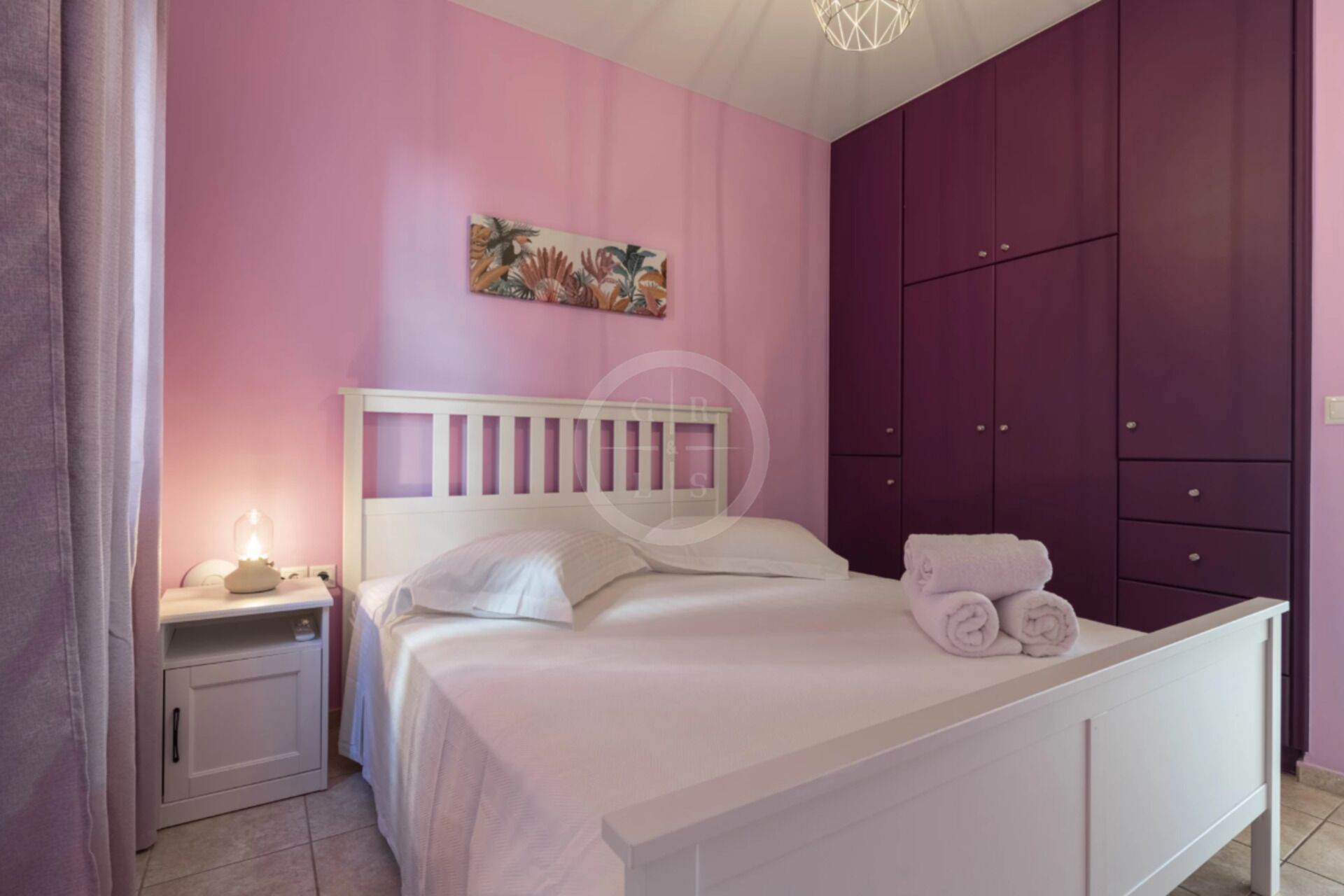 A bedroom with a bed, nightstand, and purple wardrobe.
