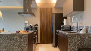 Eine moderne Küche mit Granit Arbeitsplatten, Edelstahlgeräten und Holzschränken.