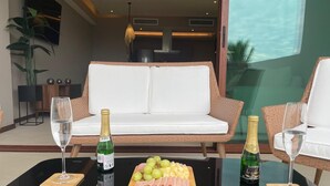 Ein modernes Wohnzimmer mit einem weißen Sofa, einem Glastisch und zwei Champagnerflaschen.