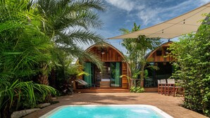 A poolside area with a wooden cabin structure, surrounded by lush greenery. - Tropical Chalet 3BR Pool Villa Pasak 3  (Choeng Thale)