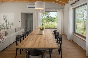 A dining area with a wooden table, black chairs, and a potted plant. - Luxury Villa Casa Maria with pool (Tar)