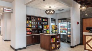 Un bar de aperitivos con estantes llenos de diversos snacks y un refrigerador.