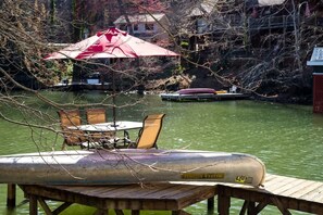 Dock with a canoe and patio table over the water