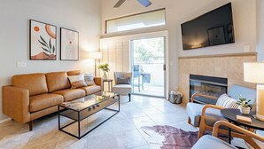 Una sala moderna con sofá, mesa de centro y chimenea.