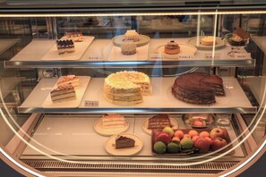 Eine Auslage mit verschiedenen Kuchen und Früchten in einer Bäckerei.